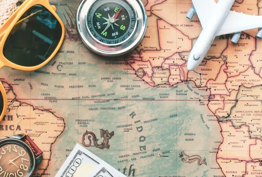 Passport, camera, and travel accessories on a world map, representing US tourist and business travel